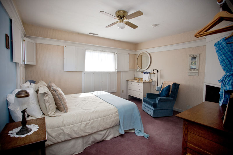 Auntie's Room, a spacious room with a queen bed and a blue armchair